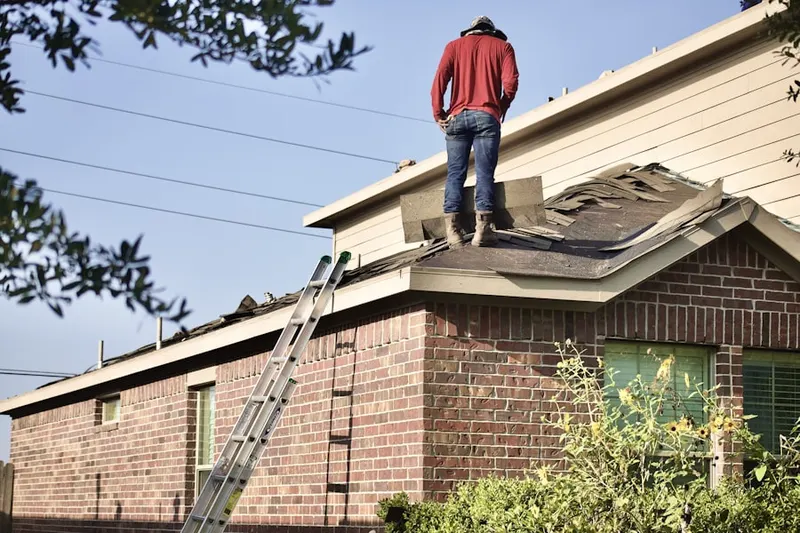 Professional roofer working on a residential roof in East Boston